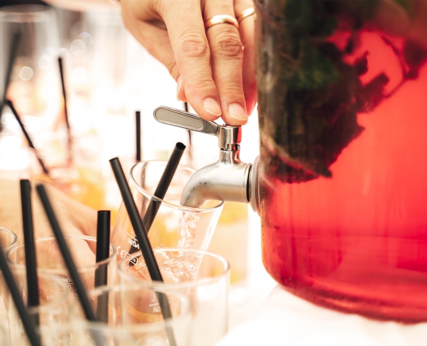 Side view of someone filling up cups with juice or punch
