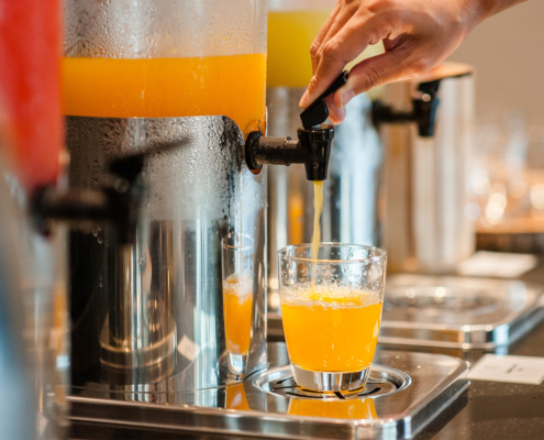 Side view of orange juice being dispensed into a cup