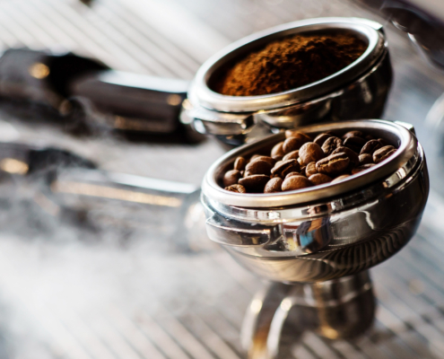 Close up of beans and grounds inside of espresso machine equipment