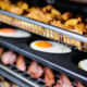 Side view of eggs and potatoes in oven tray