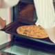 Woman preparing pizza bought in a store