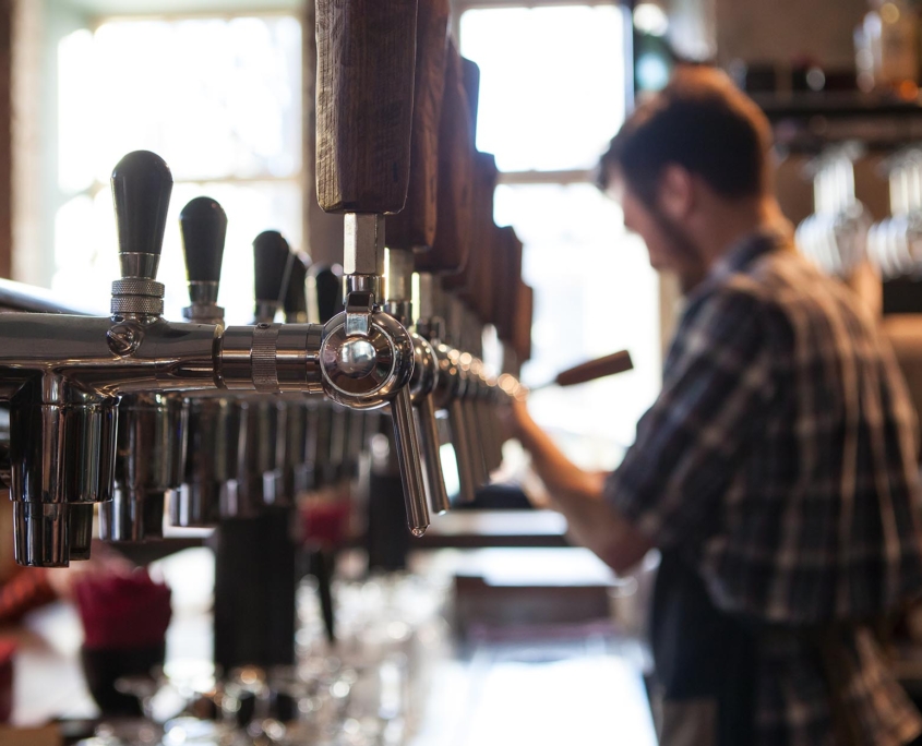 Worker filling a glass with coldbrew on tap
