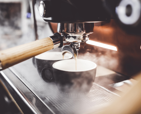 Espresso poruing from coffee machine at cafe