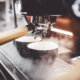 Espresso poruing from coffee machine at cafe