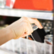 woman's hand open convenience store refrigerator shelves and pick product